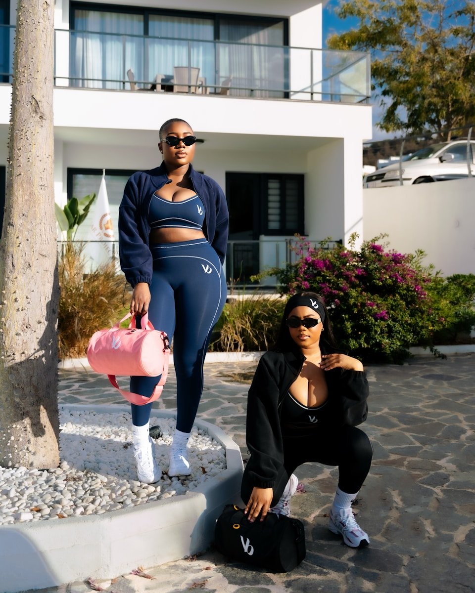 Two women in matching athletic wear posing outdoors