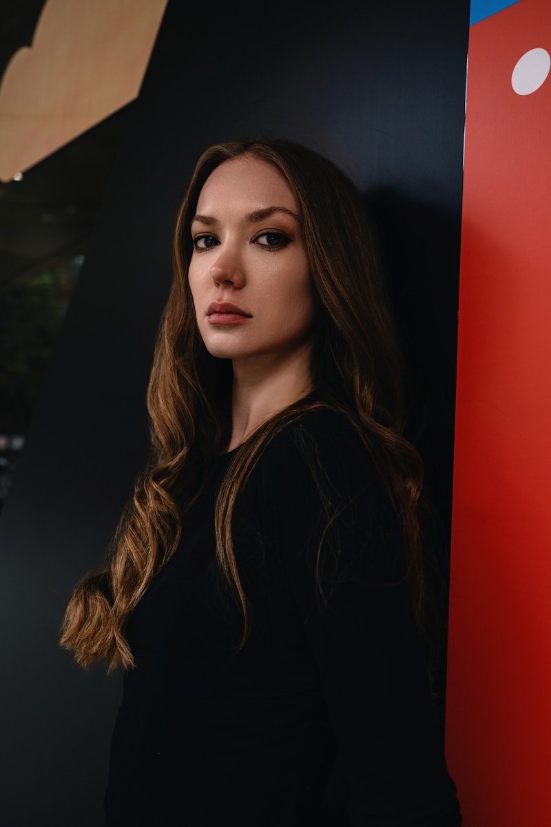 A woman standing next to a red and blue wall