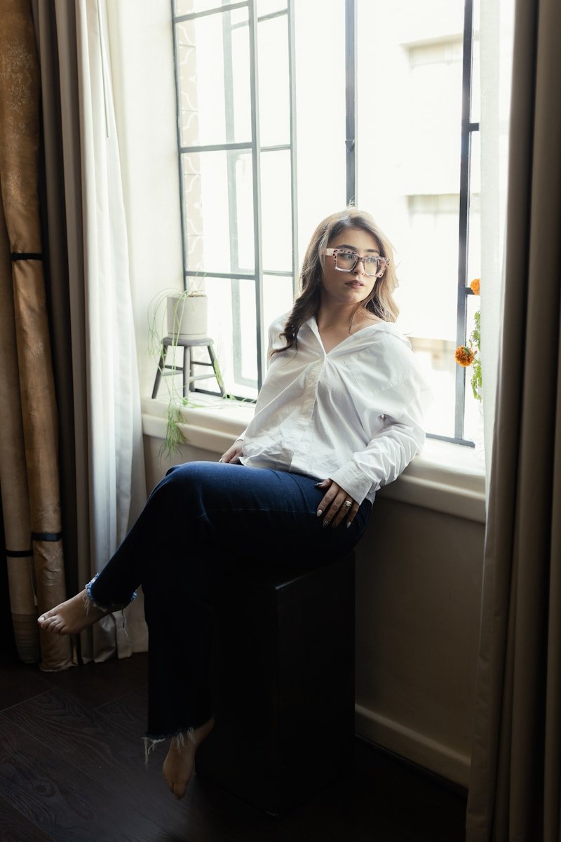 Woman in white shirt sitting by the window