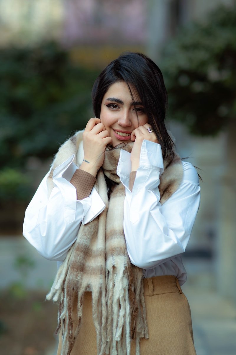 A woman wearing a scarf and white shirt outdoors